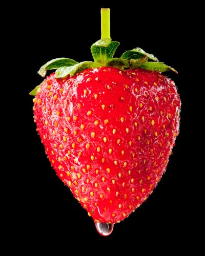 Close-up of wet ripe strawberry. Isolated on black